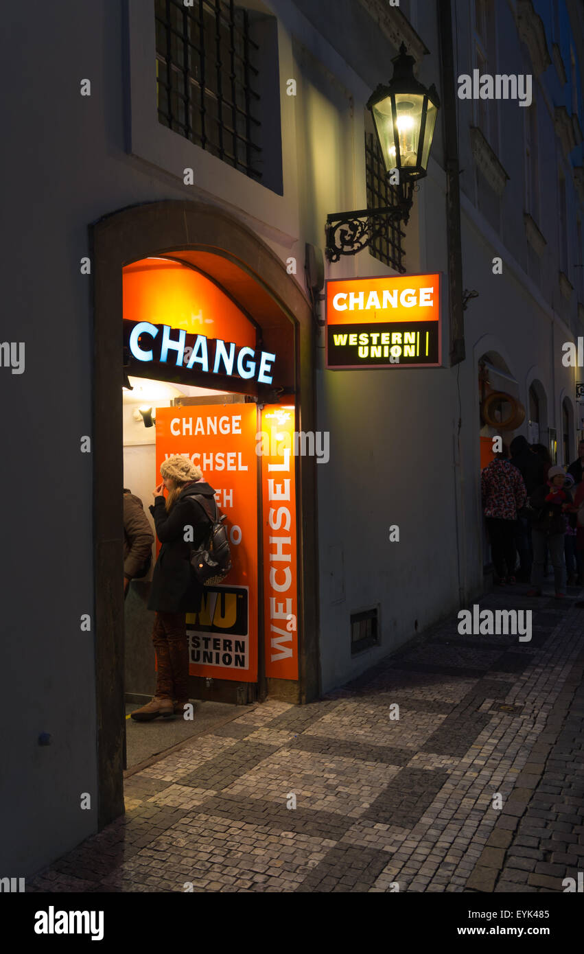 Persone sconosciute nella parte anteriore di un Western Union Money change office di notte Foto Stock