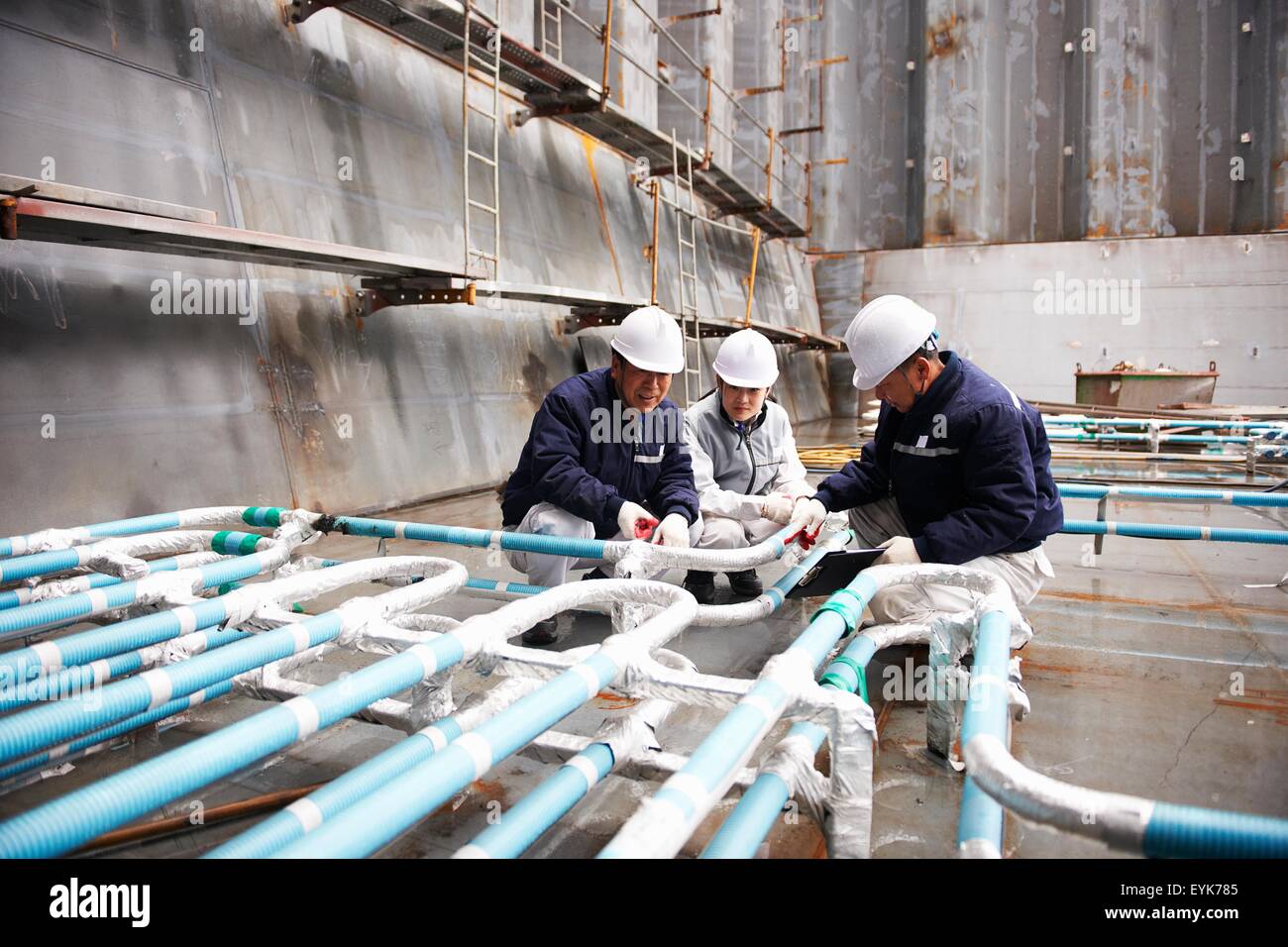 Lavoratori controllare le tubazioni sulla nave portacontainer al cantiere navale, GoSeong-gun, Corea del Sud Foto Stock