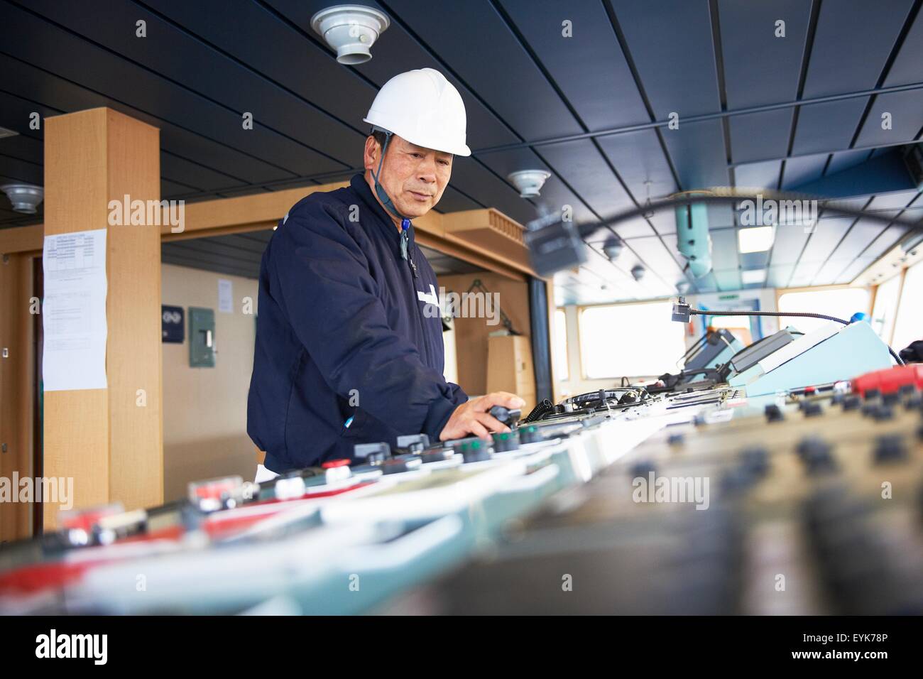 Lavoratore utilizzando apparecchiature al porto di spedizione, GoSeong-gun, Corea del Sud Foto Stock