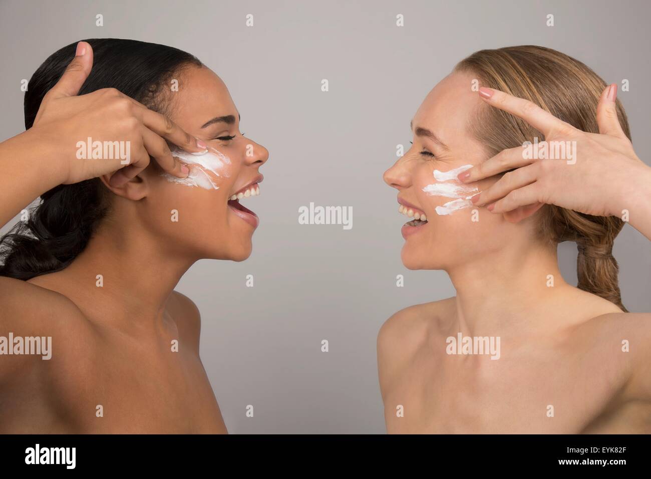 Ritratto di due giovani donne di applicare la crema di bellezza al viso Foto Stock