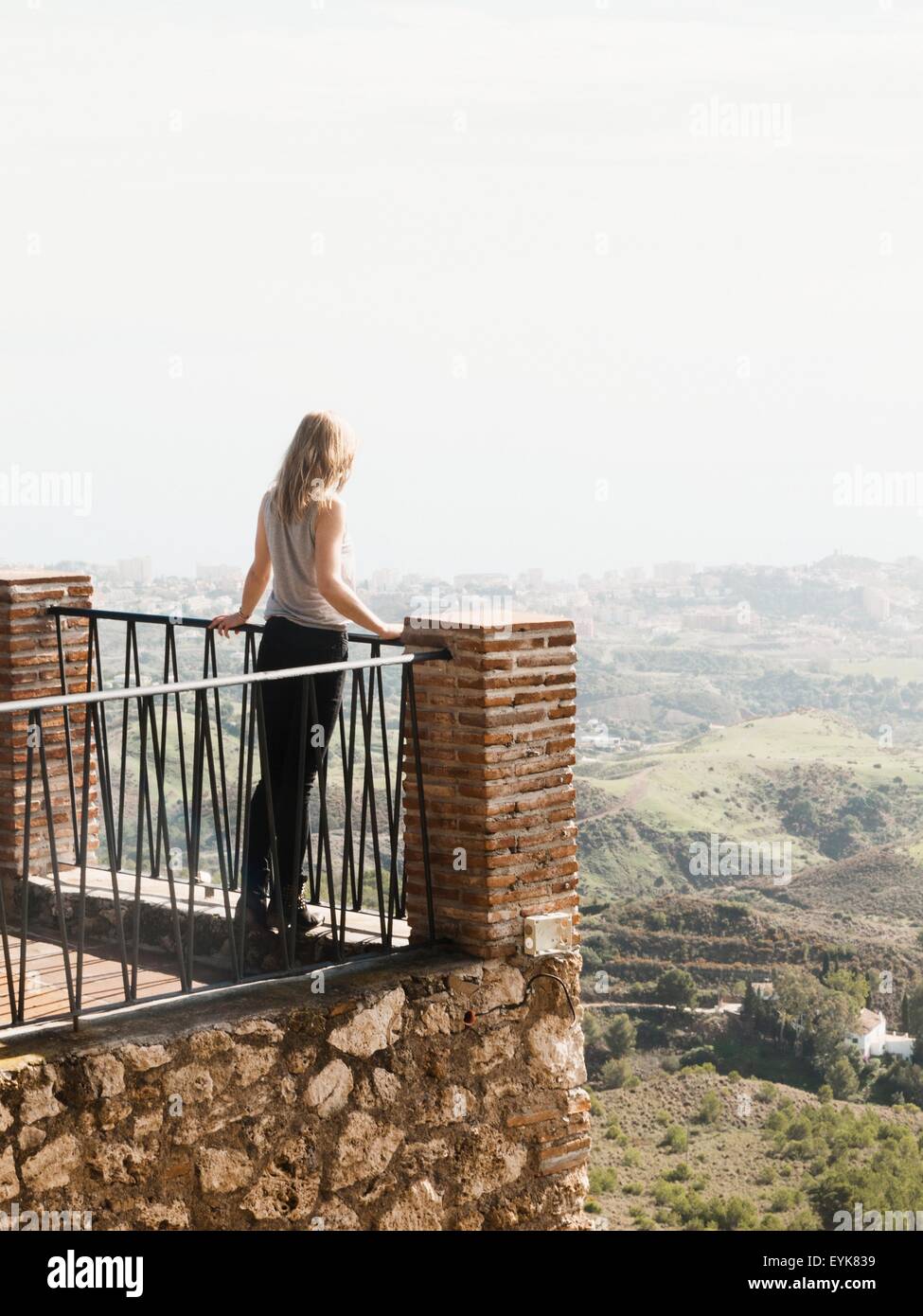 Metà donna adulta in piedi sul balcone, guardando a vista, Mijas, Andalusia, Spagna Foto Stock