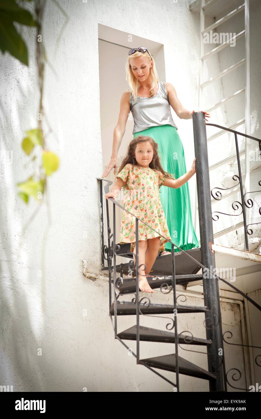 Madre e figlia camminare in metallo scale a spirale Foto Stock