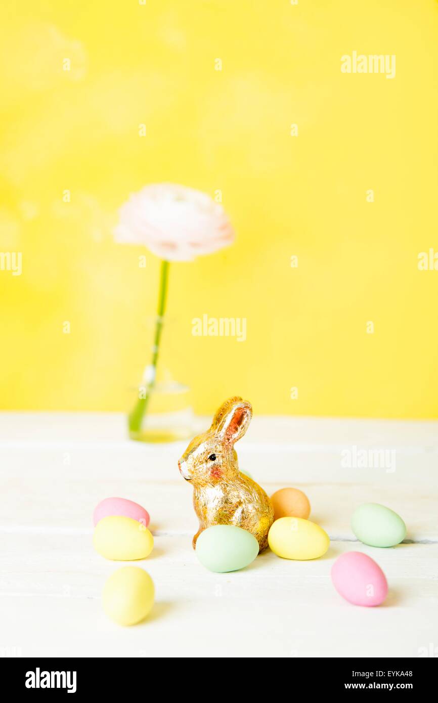 Natura morta di fiori recisi in bottiglia, uova di Pasqua e bunny Foto Stock