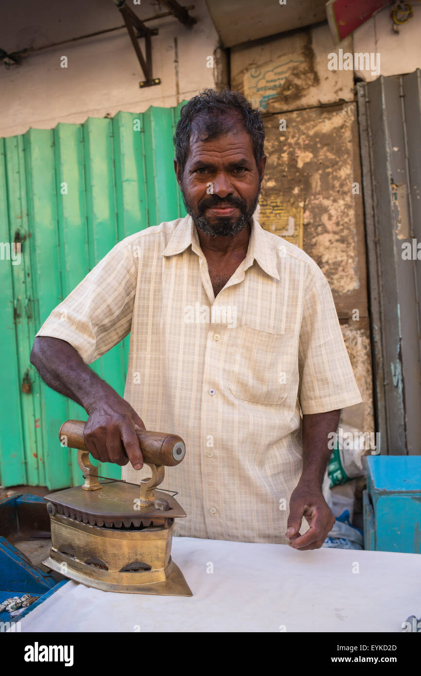 L uomo si è concentrato sulla a stirare una camicia Foto Stock