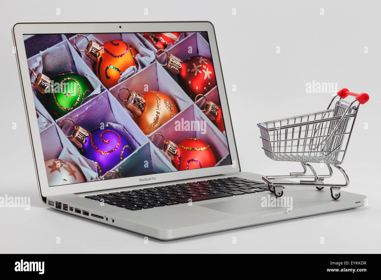 Apple MacBook per aprire, visualizzare, foto, albero di Natale sfere, carrelli di shopping, euro di banconote, immagine simbolica, shopping on-line, Foto Stock