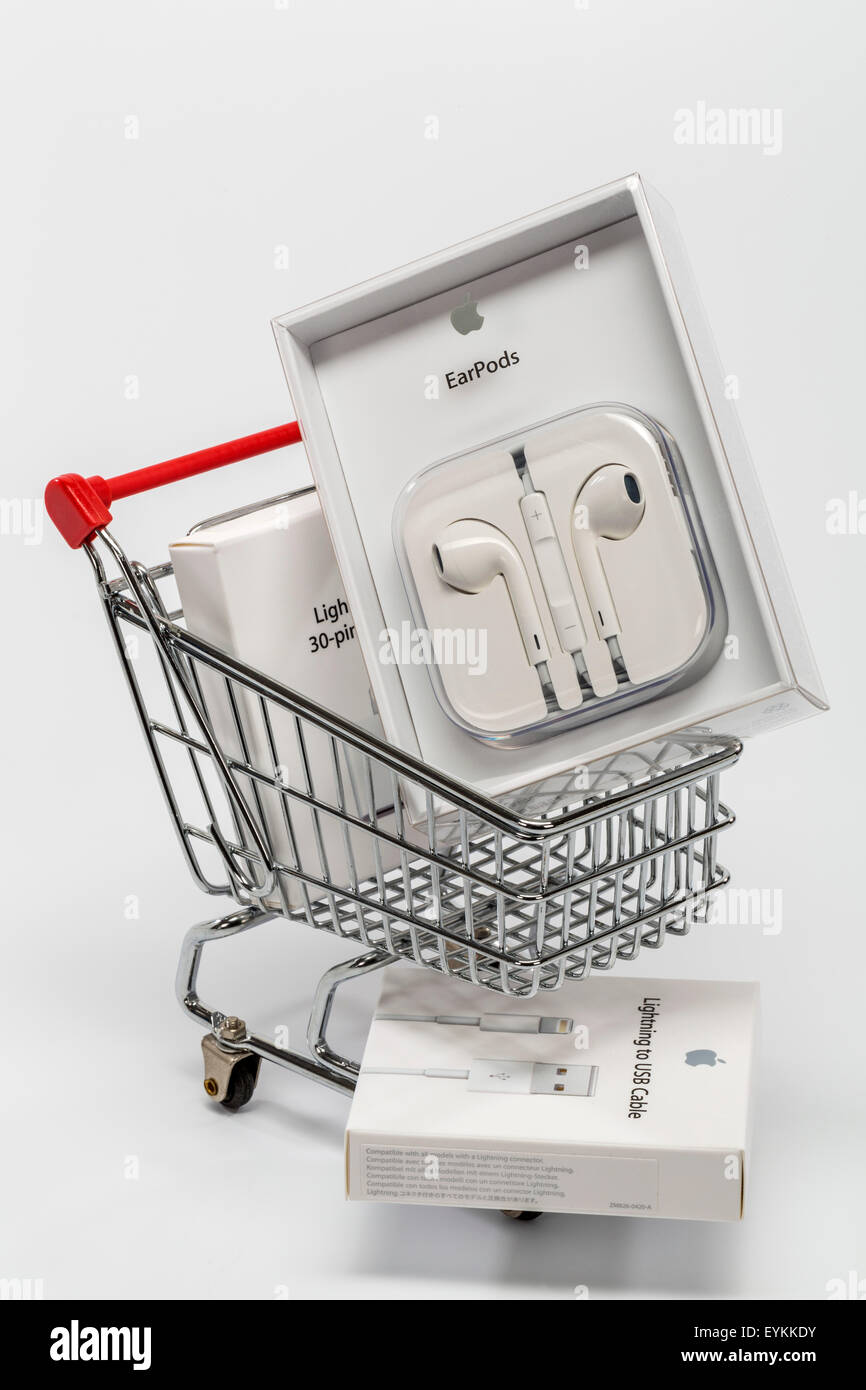 Carrelli di shopping, apparecchiature Apple, auricolare EarPods, fulmine adattatore, fulmine cavo USB nella confezione originale, immagine simbolica del consumo, Foto Stock