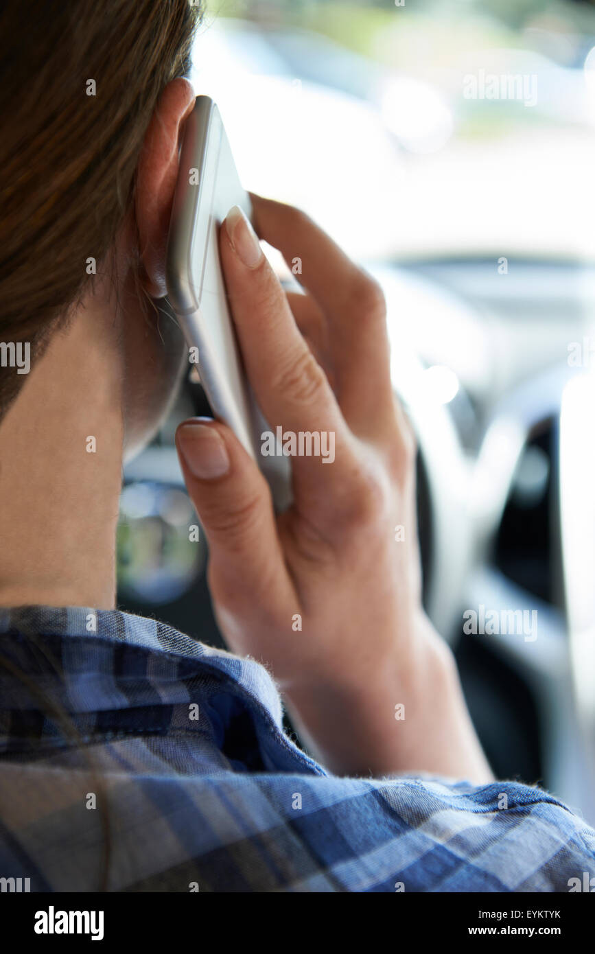 La donna in auto parlando al telefono cellulare durante la guida Foto Stock