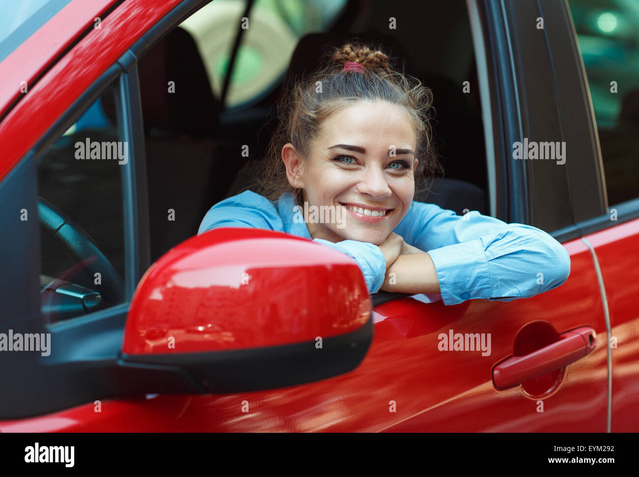 Giovane donna sorridente guidando la sua automobile Foto Stock