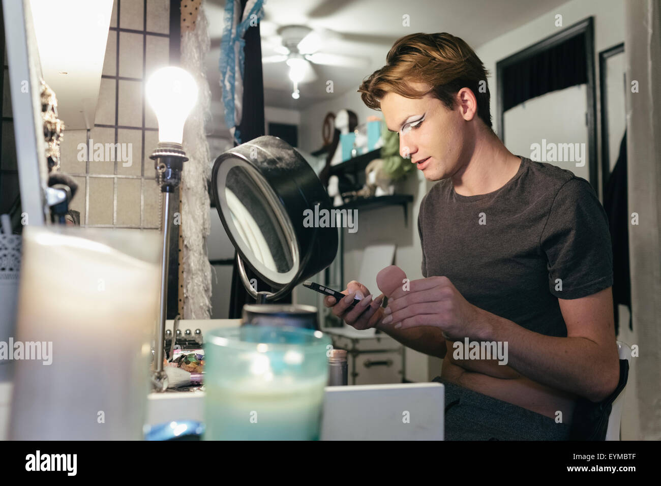 Maschio di drag queen mettendo su make up e vestirsi in prepration per una performance Foto Stock