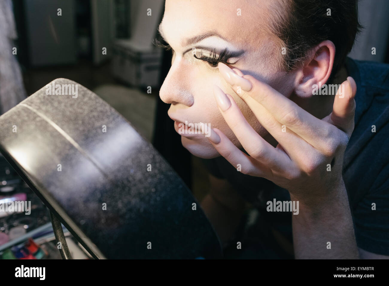 Maschio di drag queen mettendo su make up e vestirsi in preparazione per una performance Foto Stock