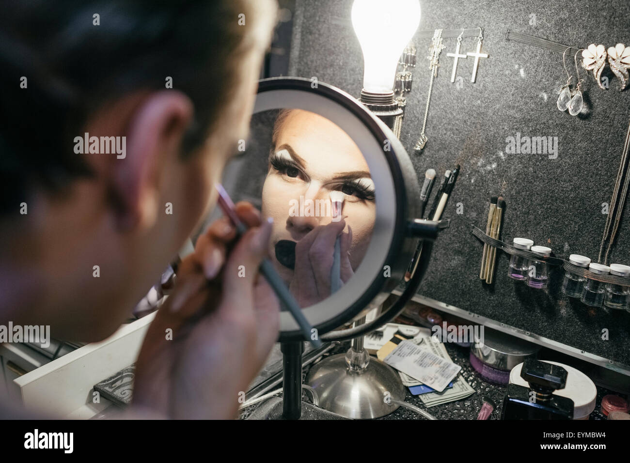 Maschio di drag queen mettendo su make up e vestirsi in preparazione per una performance Foto Stock