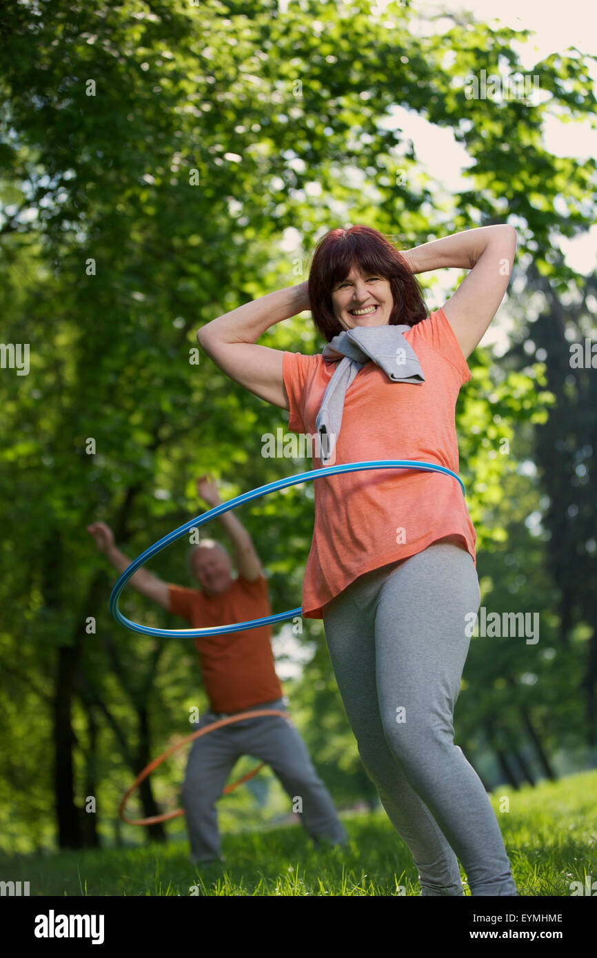 Coppia di anziani, sport, ginnastica, hula-hoop, natura Foto Stock