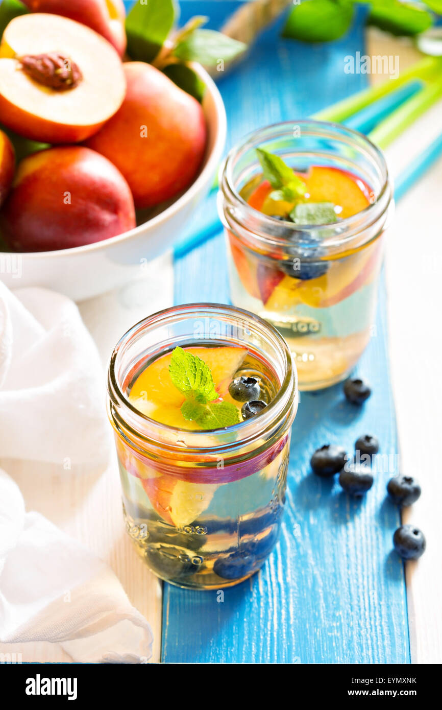 Green tè freddo con un fresco e le pesche noci e mirtilli Foto Stock