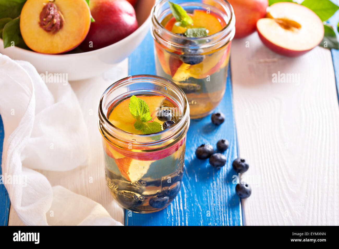 Green tè freddo con un fresco e le pesche noci e mirtilli Foto Stock