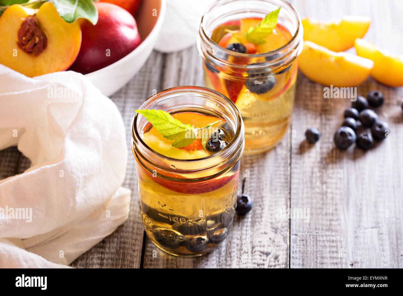 Green tè freddo con un fresco e le pesche noci e mirtilli Foto Stock