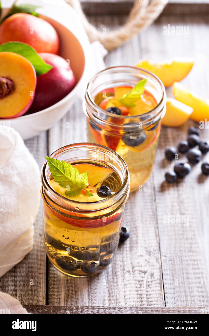 Green tè freddo con un fresco e le pesche noci e mirtilli Foto Stock