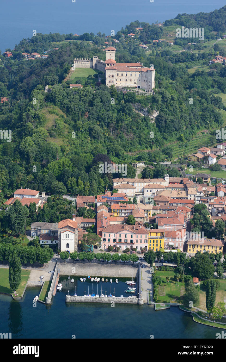 VISTA AEREA. Castello di Rocca Borromeo affacciato sul borgo medievale di Angera. Lago maggiore, Provincia di Varese, Lombardia, Italia. Foto Stock