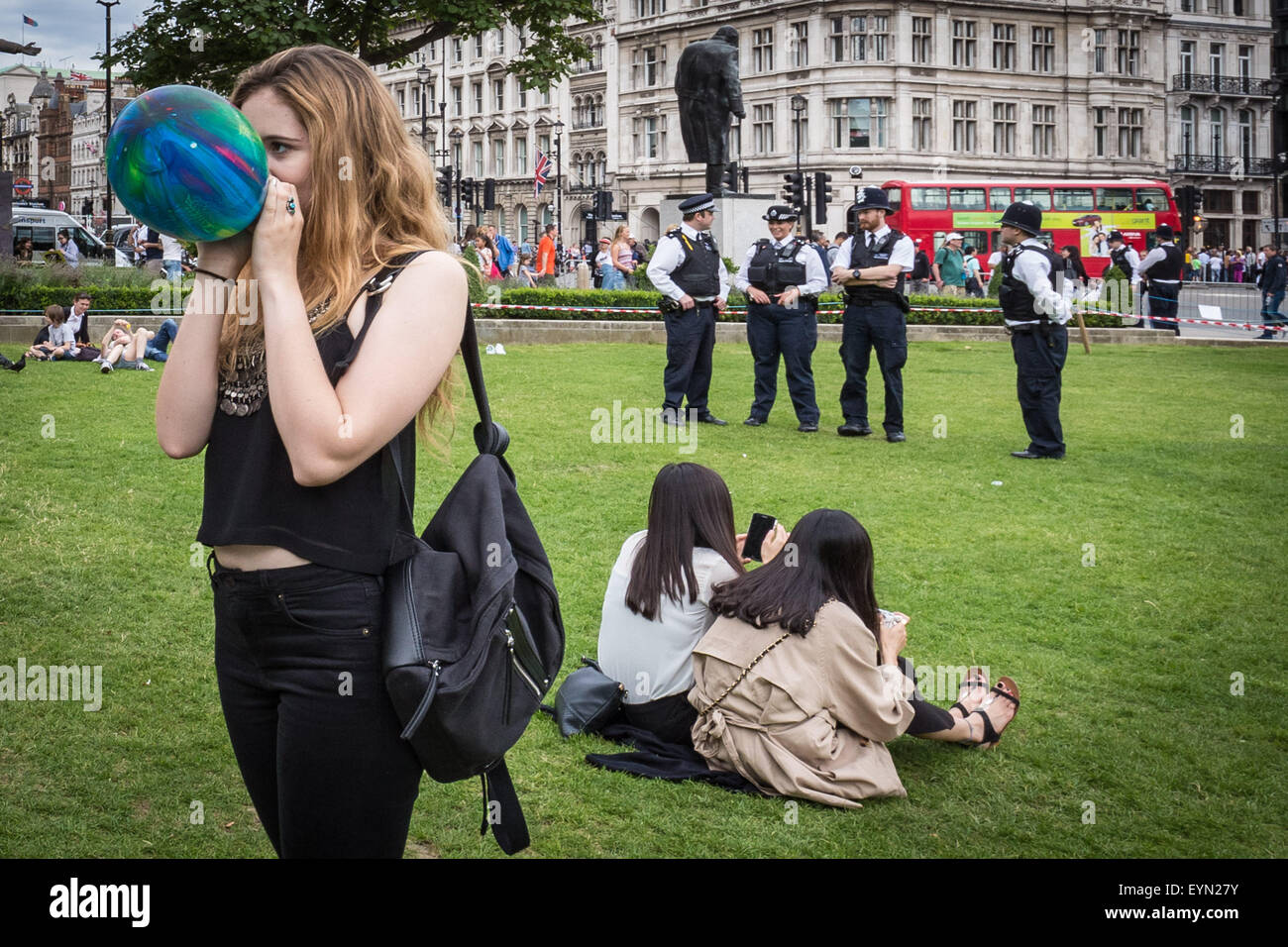 Londra, Regno Unito. Il 1 agosto, 2015. Gli attivisti di inalare palloni gonfiati con protossido di azoto, comunemente noto come "gas esilarante" per ottenere alta durante una manifestazione di protesta a Westminster la piazza del Parlamento contro una proposta di legge che mira a rendere la vendita di qualsiasi sostanza psicoattiva illegale. Credito: Guy Corbishley/Alamy Live News Foto Stock