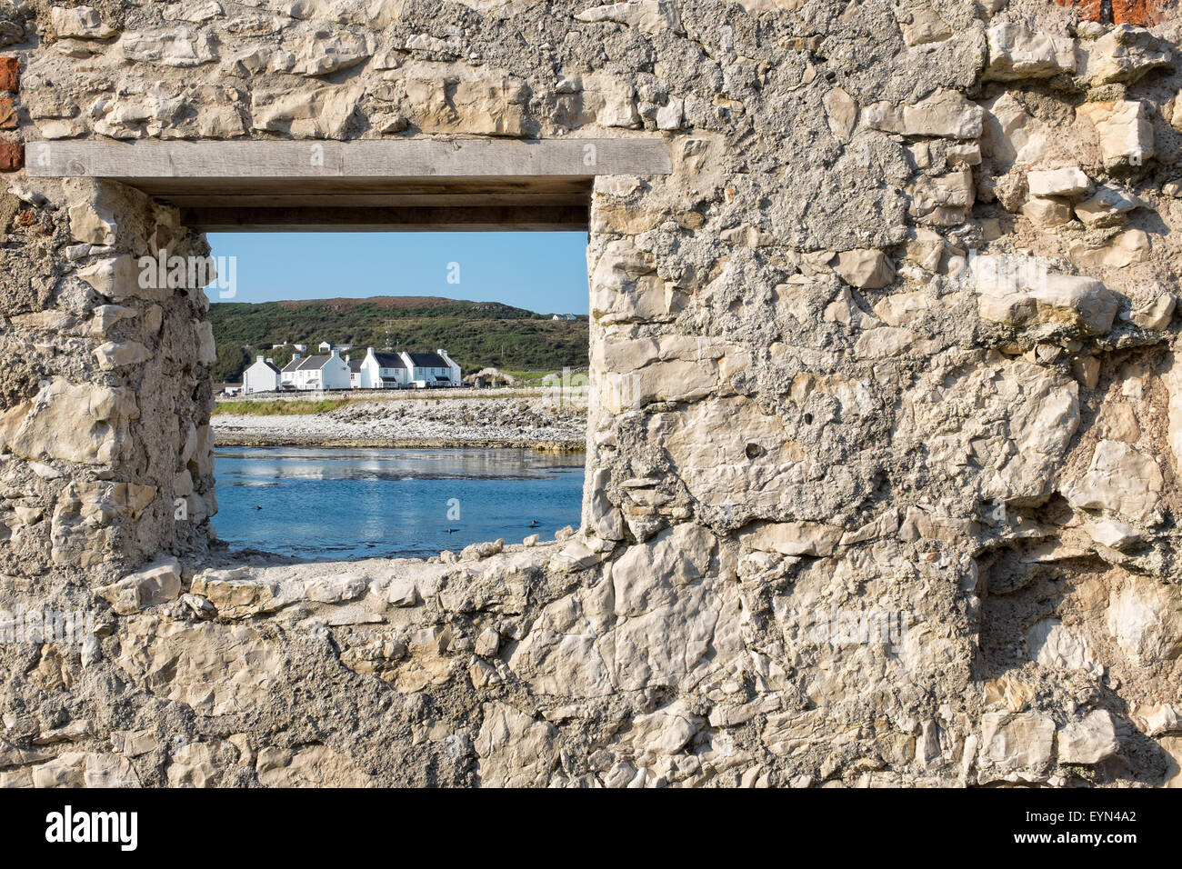 Chiesa bay village sull isola di Rathlin (Irlanda del Nord ) visto attraverso una vecchia finestra di pietra Foto Stock