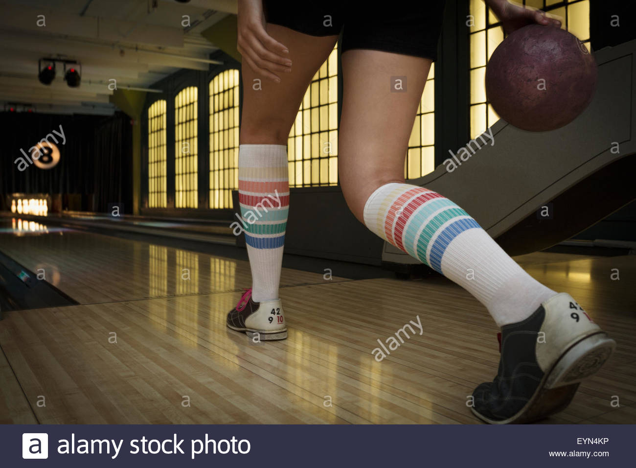 Giovane donna con il ginocchio-alte calze bowling Foto Stock
