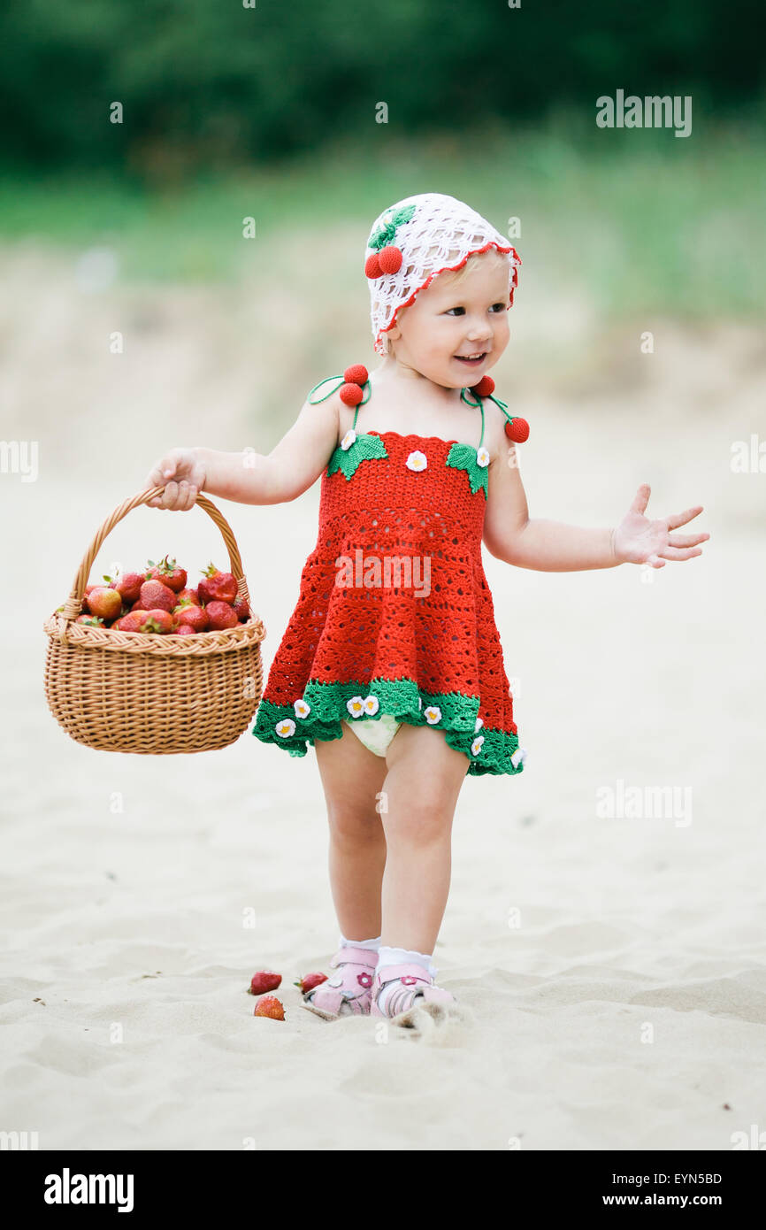 Bambina con cesto pieno di fragole Foto Stock