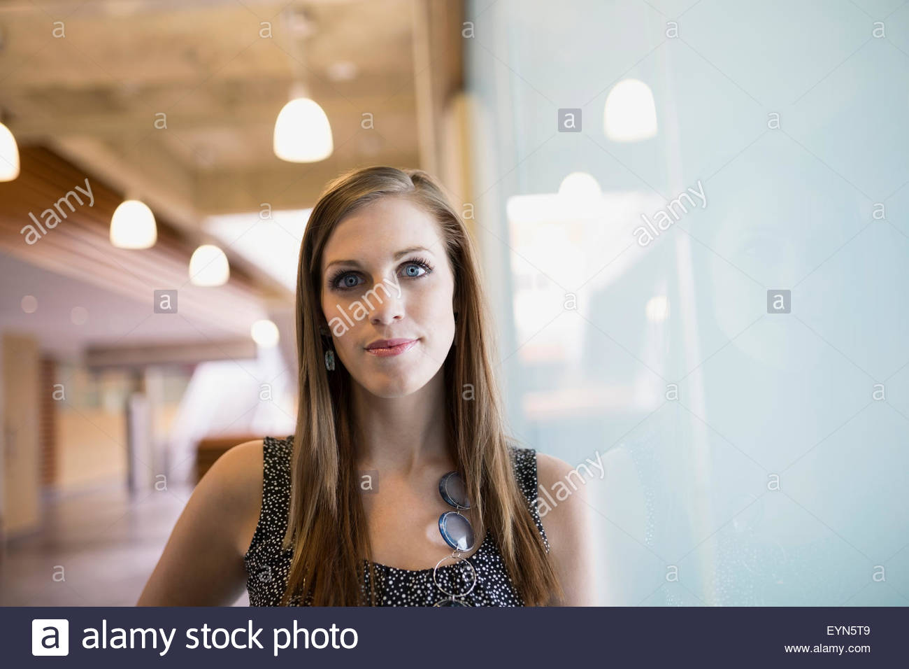 Ritratto di donna fiducioso appoggiata sulla finestra Foto Stock
