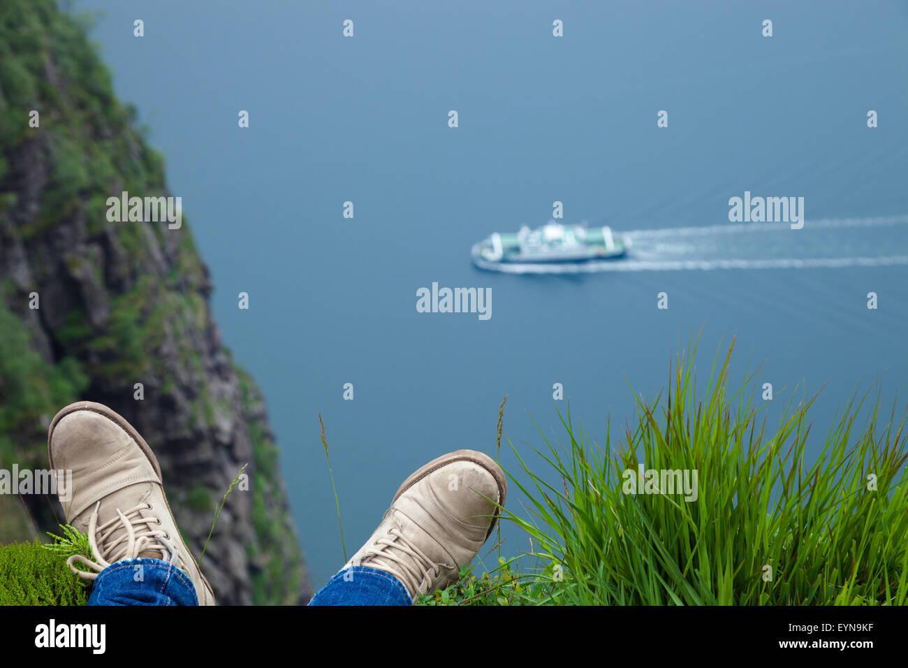 L'uomo rilassarsi sul bordo del fiordo di alti in Norvegia - la natura e la corsa dello sfondo. Foto Stock