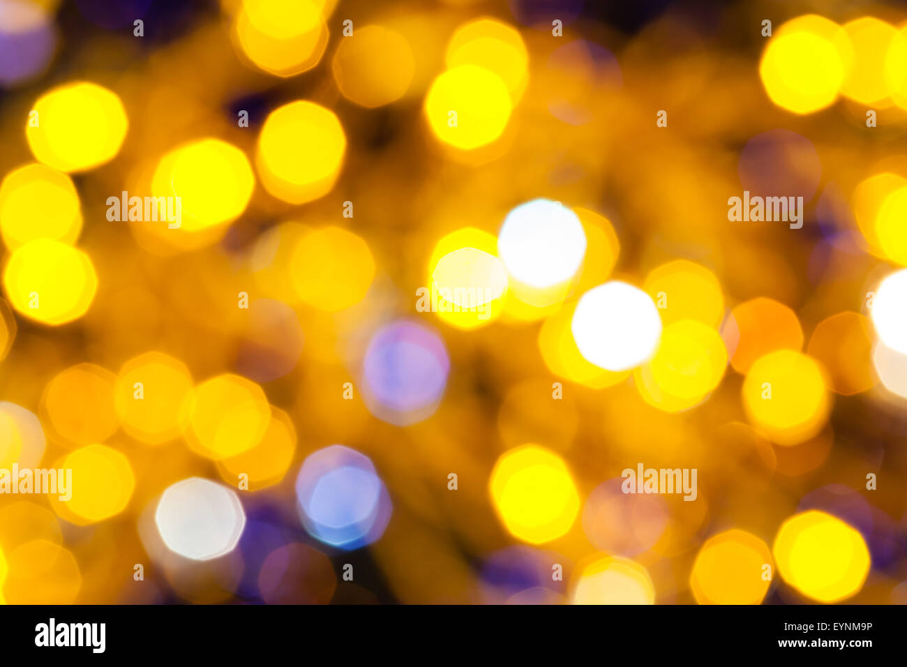 Abstract sfondo sfocato - giallo e blu scintillanti luci di Natale di le ghirlande elettriche su albero di Natale Foto Stock