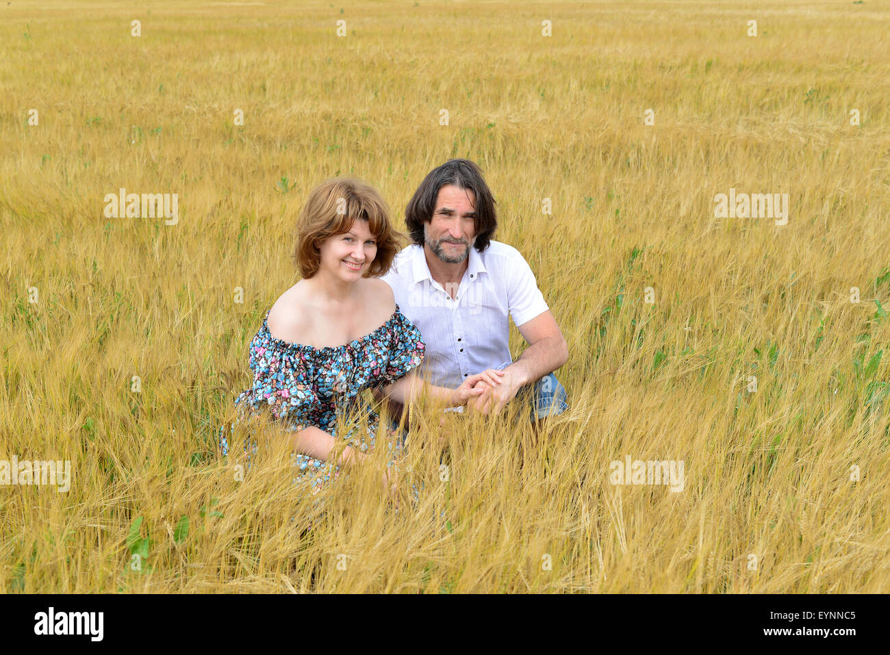 Amare di mezza età matura in piedi in un campo in estate Foto Stock