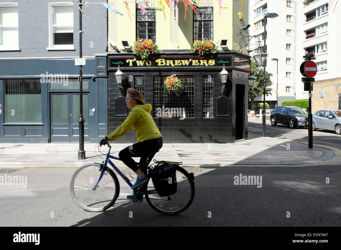 Una donna in bicicletta ultimi due produttori di birra pub in Whitecross Street London KATHY DEWITT Foto Stock