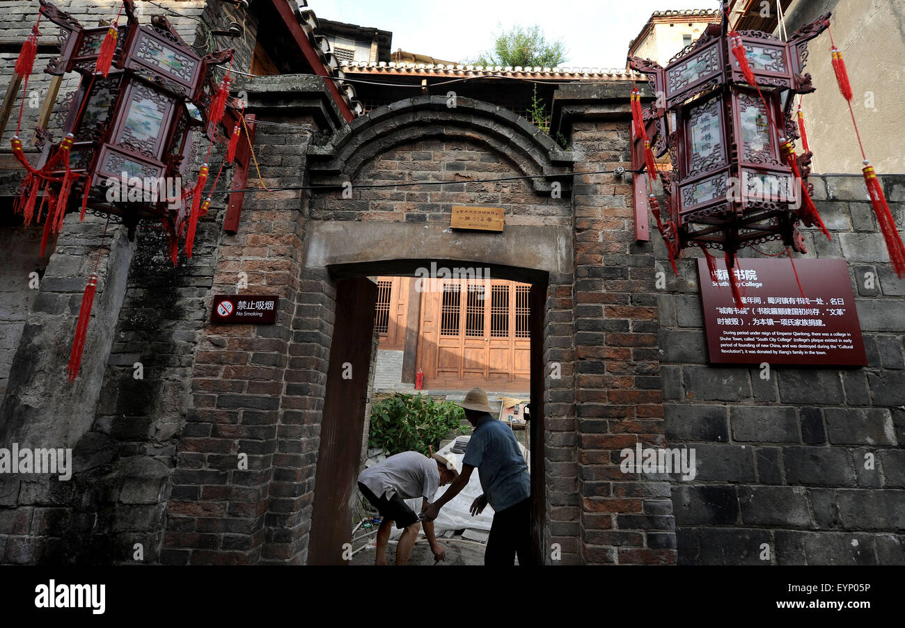 Ankang, la Cina della provincia di Shaanxi. 2 agosto, 2015. Lavoratori riparare un'antica scuola nella città di Shuhe, Xunyang County, in Cina nord-occidentale della provincia di Shaanxi, 2 agosto 2015. Situato a 53 chilometri a est di Xunyang County, Shuhe antica città era una volta un famoso porto in Cina la storia marittima. La città mette in evidenza i vecchi vicoli pieni di negozi e stand del venditore. I visitatori hanno potuto toccare le pareti di pietra di mille-anno-vecchi castelli e godere della bellezza di antichi edifici. Credito: Tao Ming/Xinhua/Alamy Live News Foto Stock