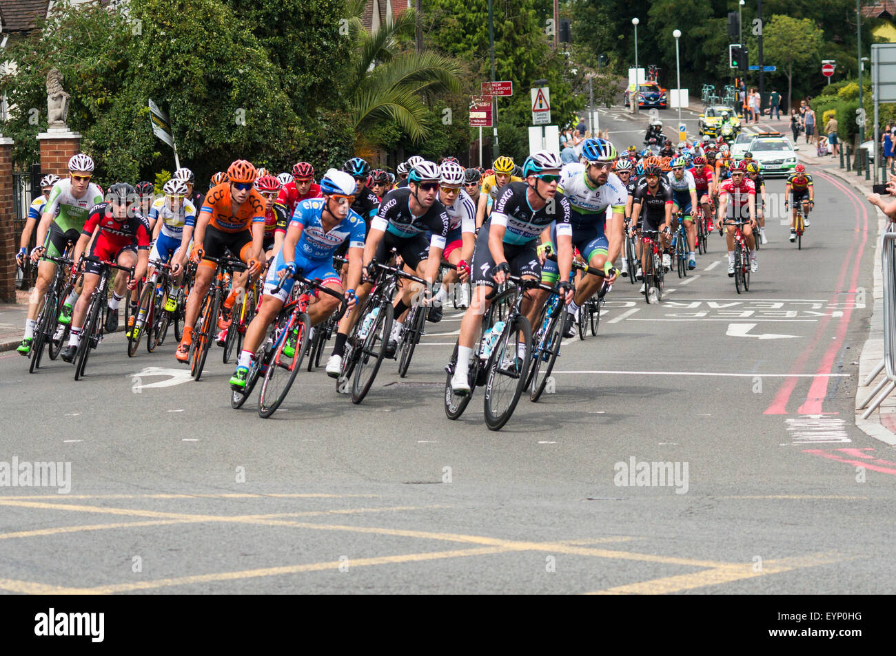 Il peloton nel Prudential RideLondon-Surrey Classic giri l'angolo di Clifford Avenue nella Upper Richmond Road, London SW14 domenica 2 agosto 2015. Prudential Ride London è un annuale di due giorni del festival di ciclismo su un percorso simile al London 2012 Giochi Olimpici gare su strada. Foto Stock