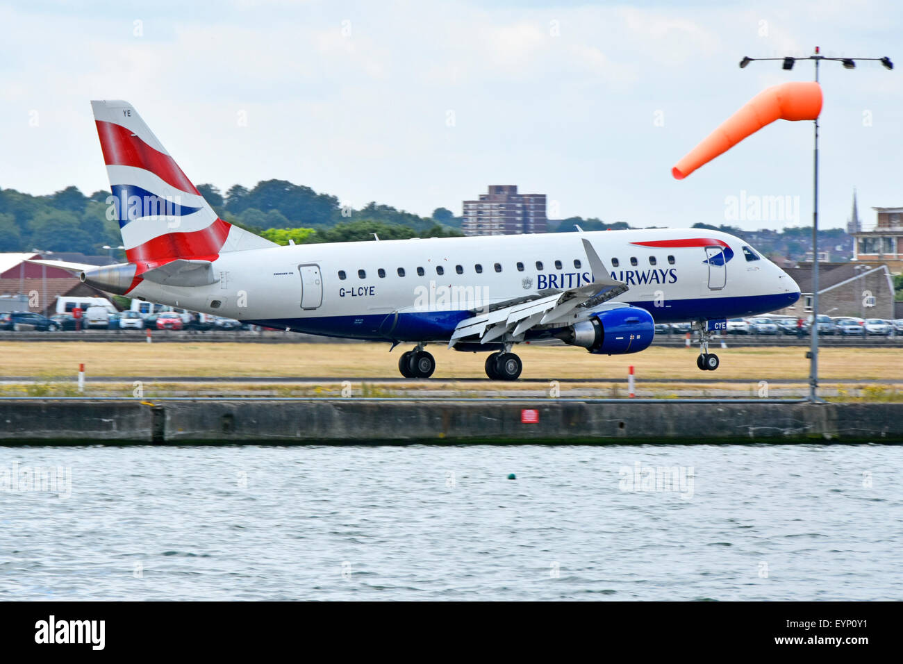British Airways Cityflyer Embraer 170 G-piano LCYE l'atterraggio all'Aeroporto di London City con manica a vento Docklands di Londra Newham Est Londra Inghilterra REGNO UNITO Foto Stock