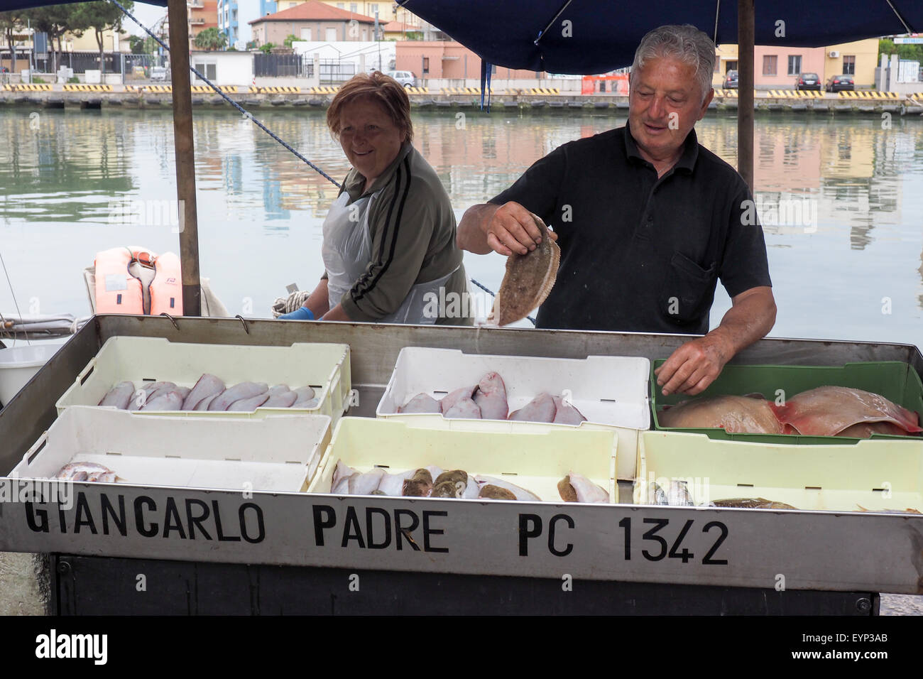 Pescivendoli vendono le loro catture del giorno sul pontile a Pescara Porto. Foto Stock