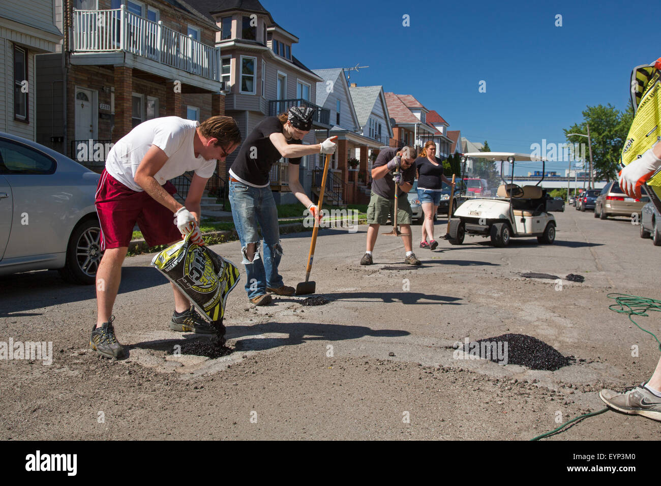 Hamtramck, Michigan - Membri della guerriglia Hamtramck riparazione su strada equipaggio riempire buche su nelle strade della città. Foto Stock
