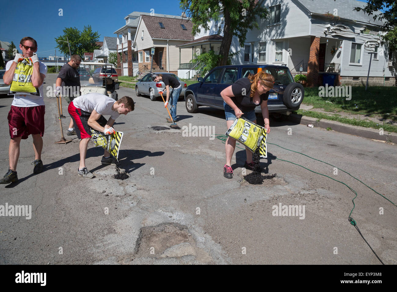 Hamtramck, Michigan - Membri della guerriglia Hamtramck riparazione su strada equipaggio riempire buche su nelle strade della città. Foto Stock