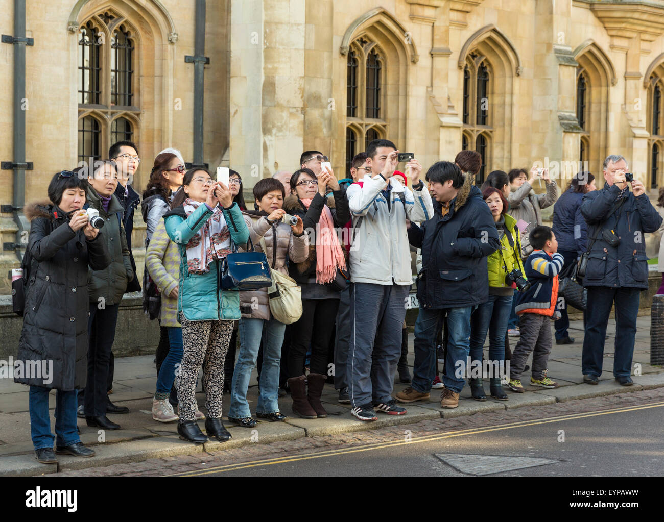 Gruppo di turisti cinesi su Cambridge St in Cambridge Inghilterra pausa insieme per scattare fotografie Foto Stock