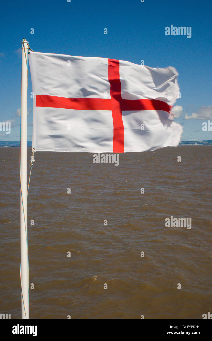 Bandiera inglese (St George's bandiera) volare nel vento con il mare alle spalle, Clevedon pier, Somerset, Regno Unito Foto Stock