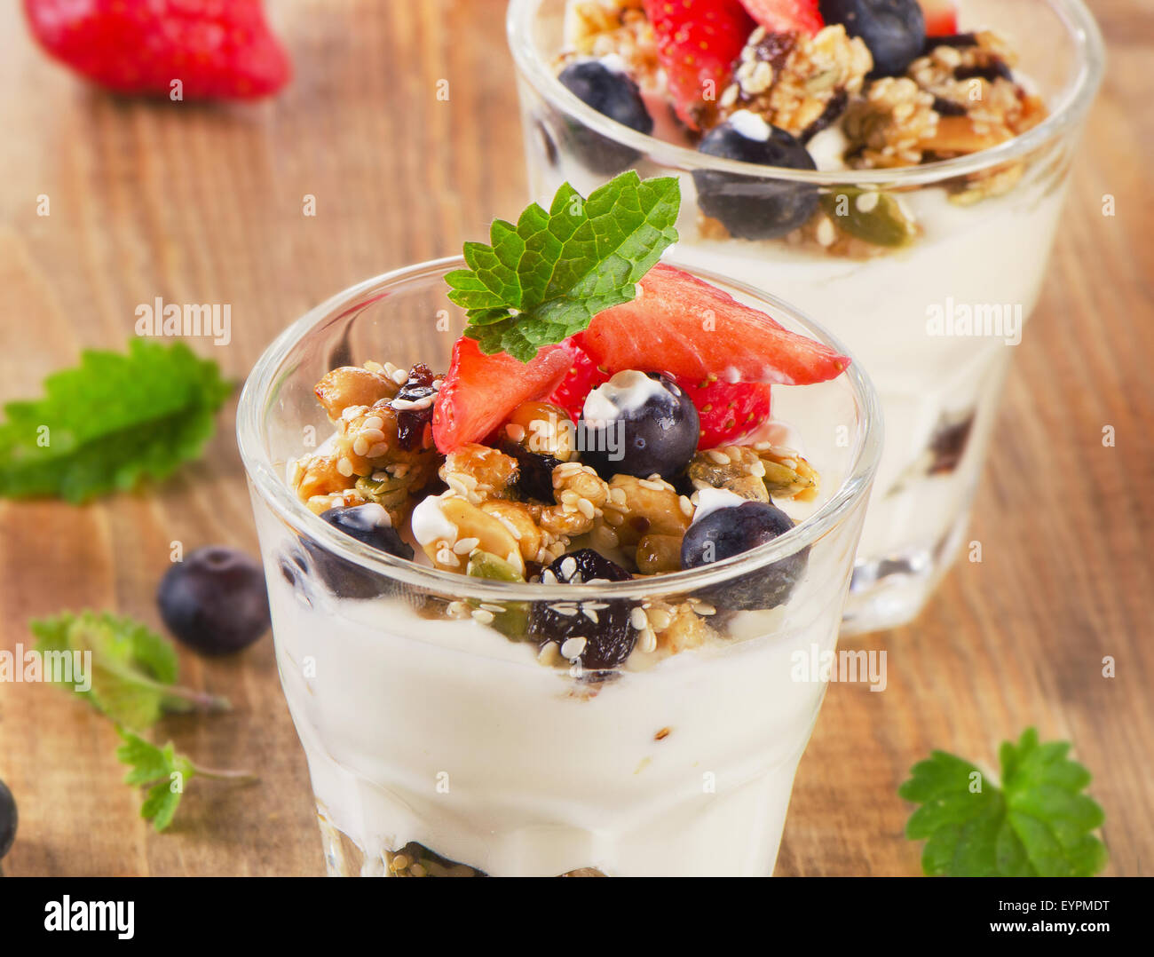 Yogurt con cereali e frutti di bosco freschi in legno rustico sfondo. Messa a fuoco selettiva Foto Stock