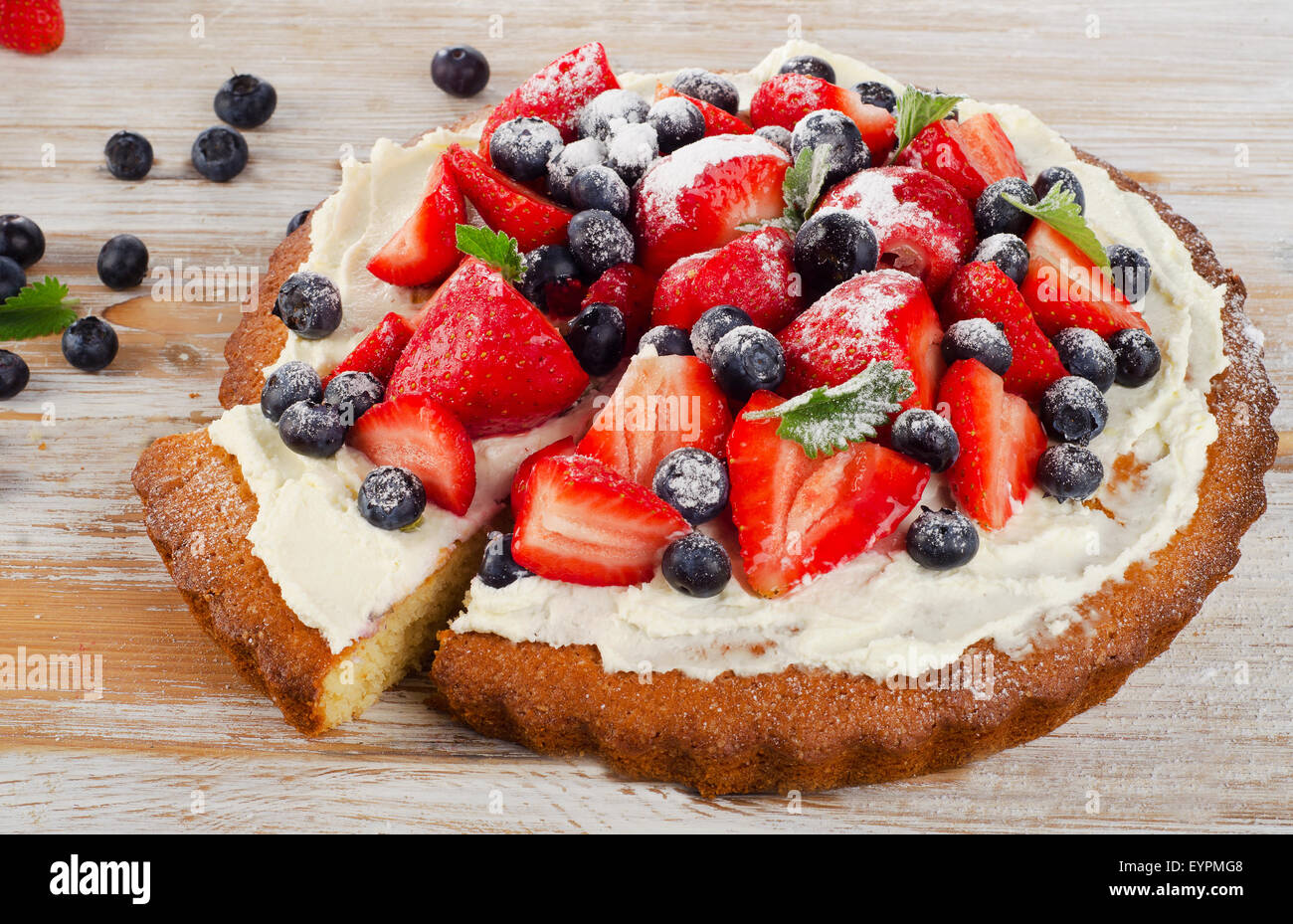 Torta dolce con frutti di bosco su sfondo di legno. Messa a fuoco selettiva Foto Stock