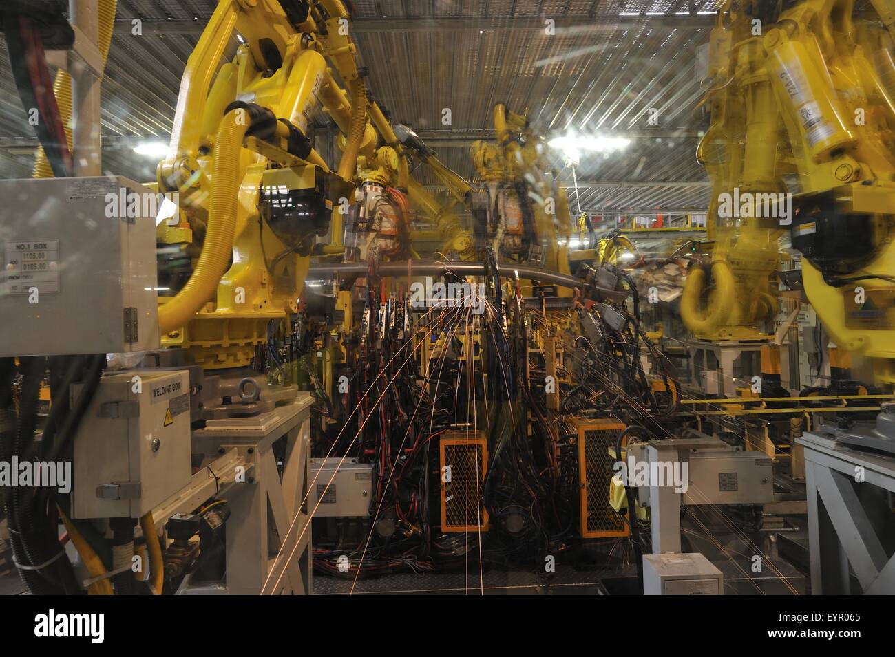 All'interno di una moderna fabbrica di automobili e veicoli e parti si muovono attraverso il processo di produzione, robot blur Foto Stock