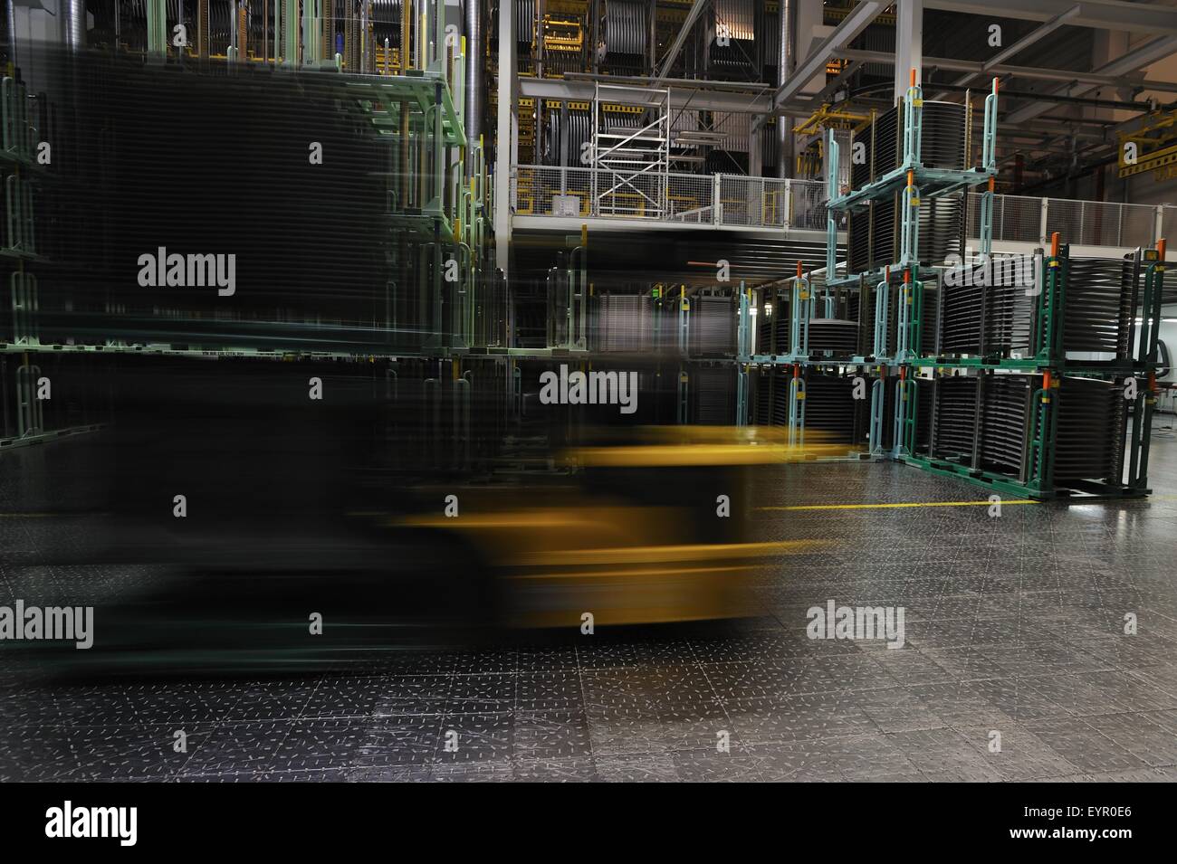 All'interno di una moderna fabbrica di automobili e veicoli e parti si muovono attraverso il processo di produzione, il carrello elevatore a forche si sfoca attraverso il magazzino Foto Stock