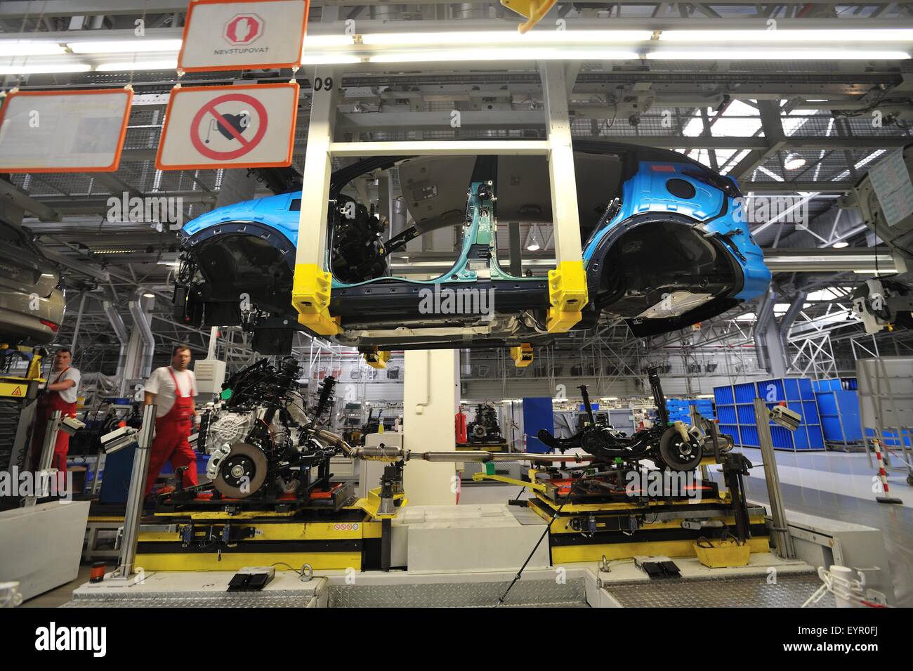 All'interno di una moderna fabbrica di automobili e veicoli e parti si muovono attraverso il processo di produzione, corpo sospeso e il treno di azionamento al di sotto di Foto Stock