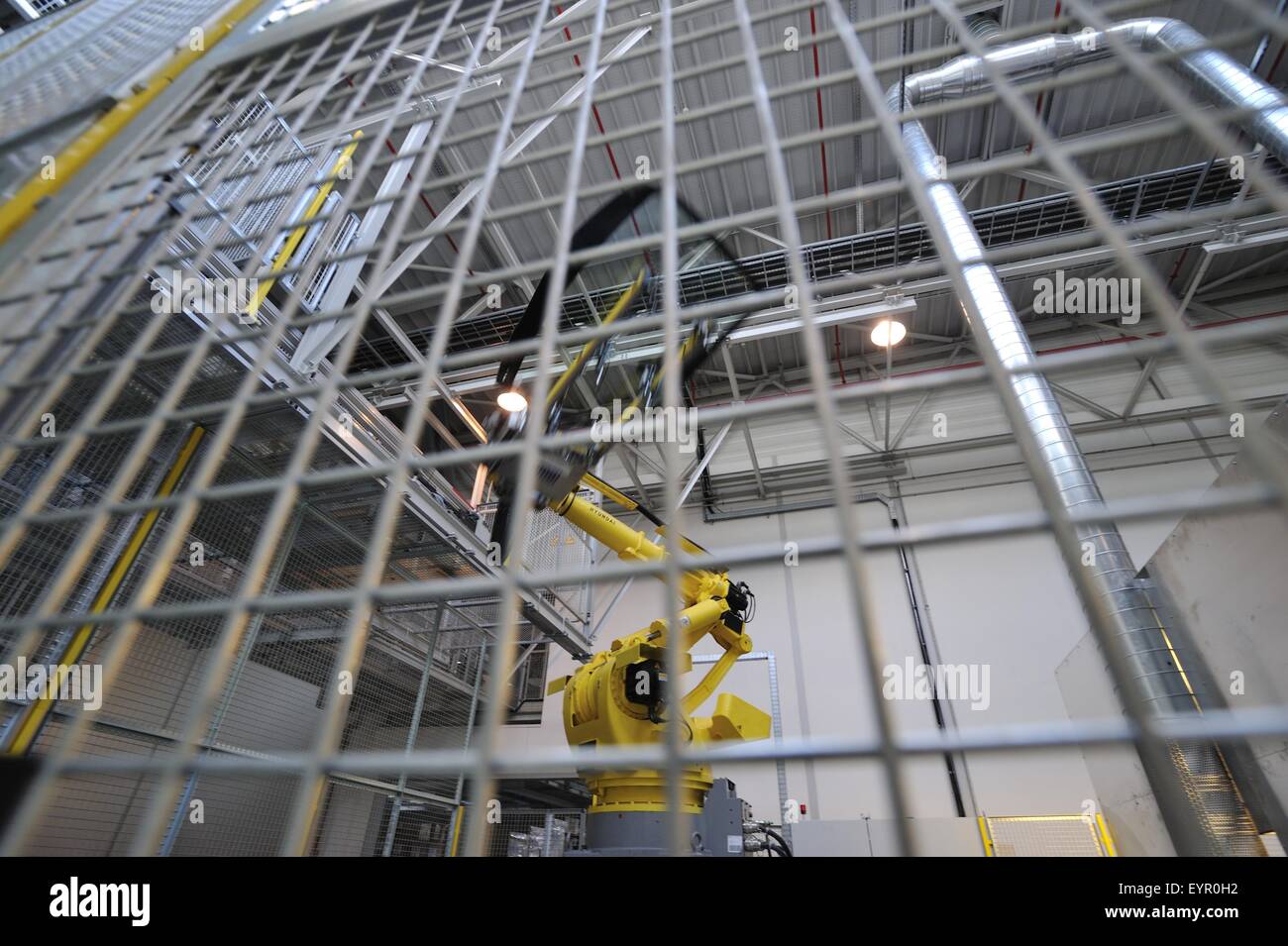All'interno di una moderna fabbrica di automobili e veicoli e parti si muovono attraverso il processo di produzione, il robot in una gabbia Foto Stock