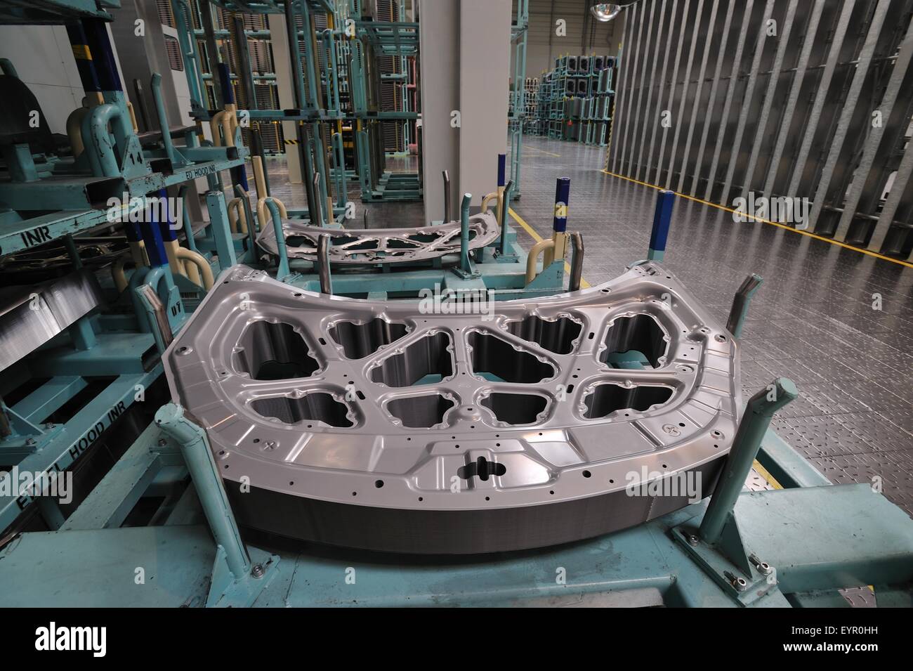 All'interno di una moderna fabbrica di automobili e veicoli e parti si muovono attraverso il processo di produzione, cofano nervature di rinforzo Foto Stock