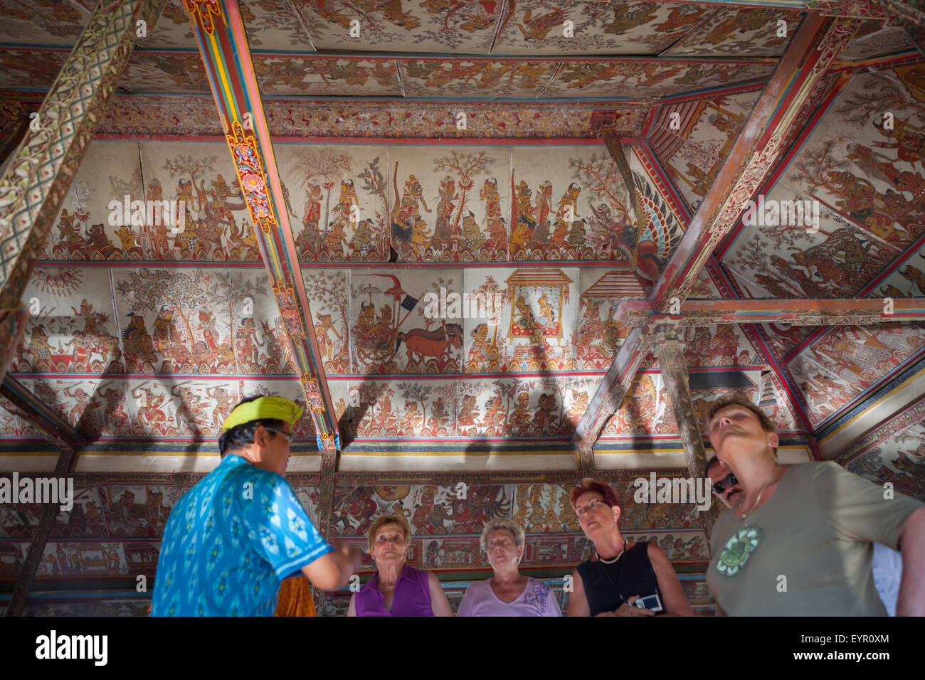 I turisti stanno prestando attenzione al soffitto dell'iconico padiglione Kertha Gosa che mostra il vecchio e tradizionale stile di pittura Balinese a Klungkung, Bali. Foto Stock