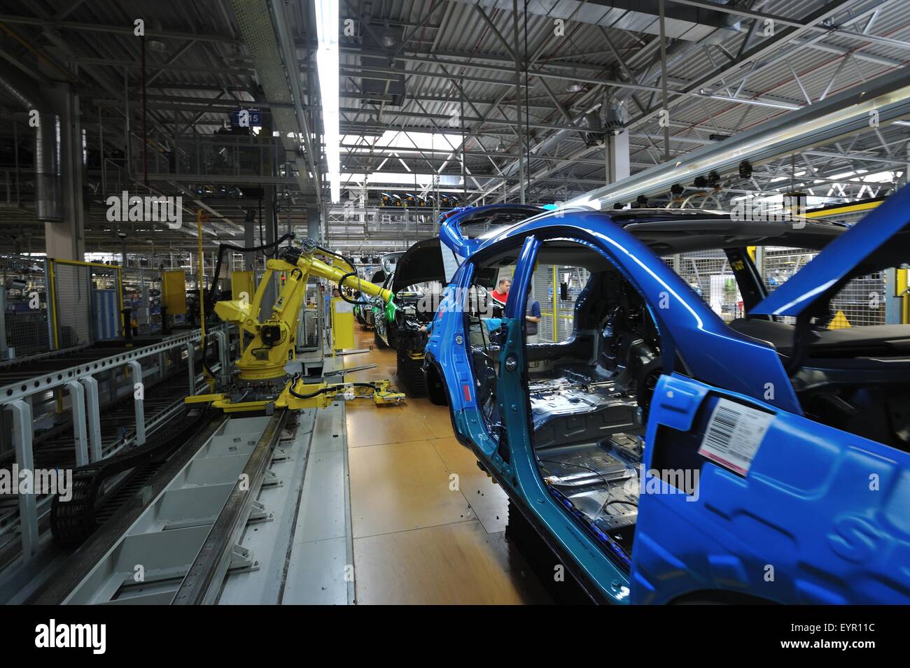 All'interno di una moderna fabbrica di automobili e veicoli e parti si muovono attraverso il processo di produzione, il robot funziona su scocca Foto Stock