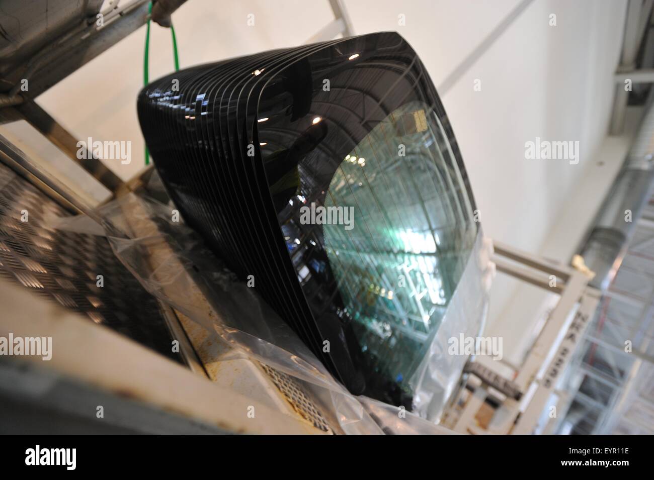 All'interno di una moderna fabbrica di automobili e veicoli e parti si muovono attraverso il processo di produzione, vetri posteriori impilati pronti per montare Foto Stock