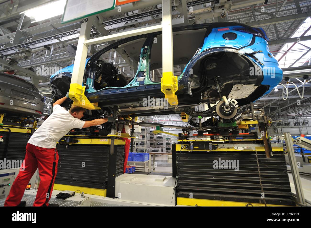 All'interno di una moderna fabbrica di automobili e veicoli e parti si muovono attraverso il processo di produzione, il lavoro si unisce il sollevamento treno di guida Foto Stock