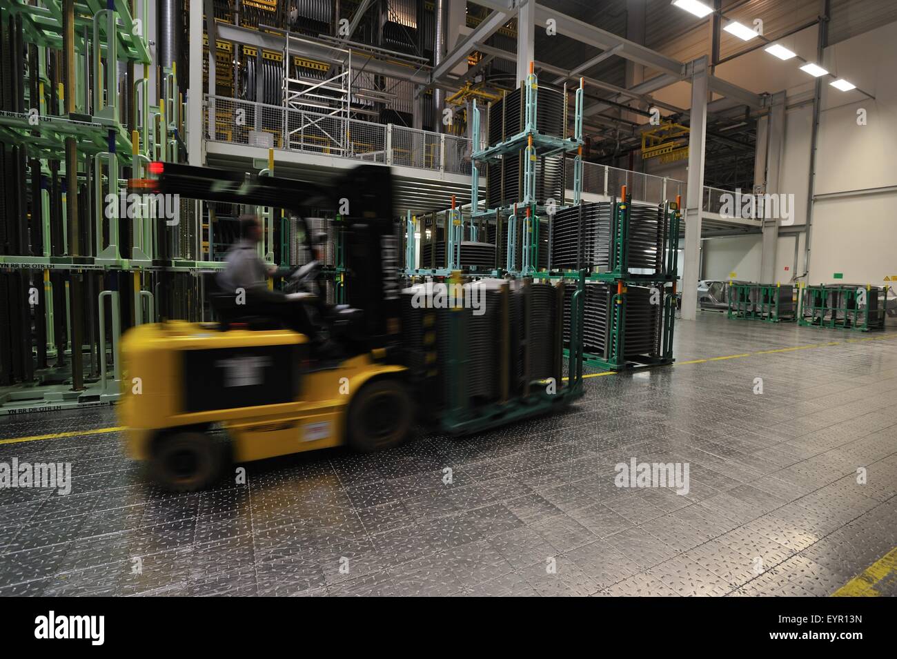 All'interno di una moderna fabbrica di automobili e veicoli e parti si muovono attraverso il processo di produzione, carrello elevatore trasporta una pila di parti Foto Stock
